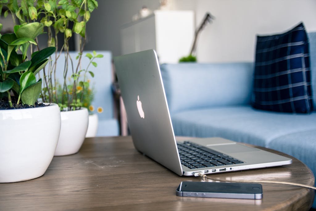 Un bureau moderne avec un ordinateur portable, un téléphone, des plantes vertes qui symbolises la diversité des sujets liés à une vente ou acquisition en viager.